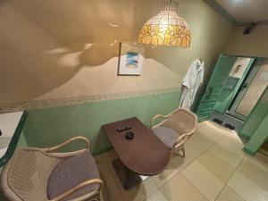 a bathroom with a table and two chairs and a light at Hotel Esta in Miyazaki