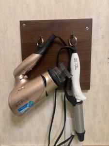 a hair dryer and a blow dryer on a wall at Hotel Esta in Miyazaki