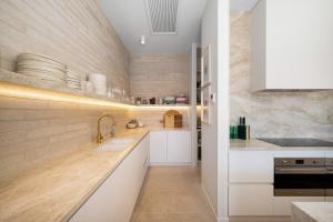 a kitchen with white cabinets and a sink at Lucia Sorrento in Sorrento +12 photos