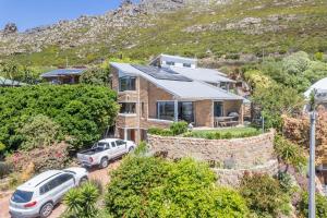 a house with two cars parked in front of it at 3BR Lakeside Home Mountains Beach Nearby in Cape Town