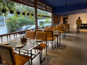 a restaurant with tables and chairs and a man walking in the background at Blu Resorts in Vagator