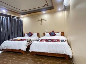 two beds sitting next to each other in a room at MAI CHAU inn in Mai Châu