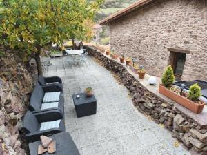 a patio with benches and a table and a stone building at Casa Fabiana in Montenegro de Cameros