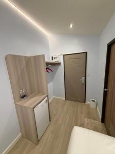 a room with a bed and a desk and a door at ของขวัญรีสอร์ท in Ban Khlong Ai Kok
