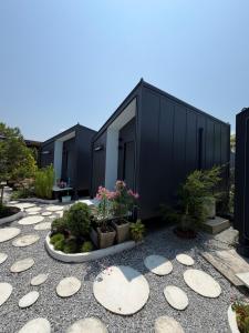 a row of black buildings with potted plants at ของขวัญรีสอร์ท in Ban Khlong Ai Kok