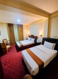 a hotel room with two beds and a chair at Keba Guest House - Addis Ababa in Addis Ababa +11 photos
