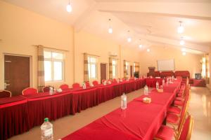 a large room with red tables and chairs with water bottles at Center Park Resort Pvt.Ltd in Sauraha +49 photos