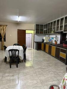 a kitchen with a table and chairs in a room at De JITRA 2 HOMESTAY in Jitra