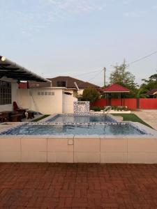 a large pool in a patio with a table and chairs at De JITRA 2 HOMESTAY in Jitra