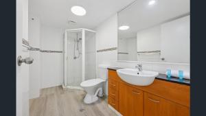 a bathroom with a sink and a toilet and a mirror at Palazzo Colonnades in Gold Coast