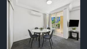 a dining room with a table and chairs and a television at Palazzo Colonnades in Gold Coast