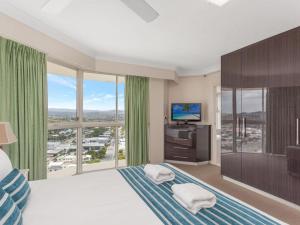 a bedroom with a large bed with a large window at Burleigh Surf Apartments in Gold Coast