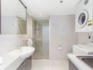 a white bathroom with a sink and a shower at Burleigh Surf Apartments in Gold Coast +11 photos