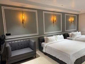 a bedroom with two beds and a couch and lights at Dusk and Dawn Beach Resort in Rāmeswaram