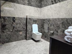 a bathroom with a toilet and a shower at The Tranquil hotel in Chakrāta