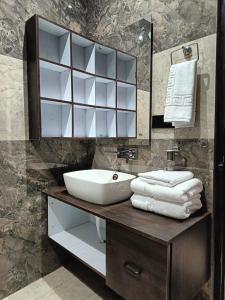 a bathroom with a sink and a mirror and towels at The Tranquil hotel in Chakrāta