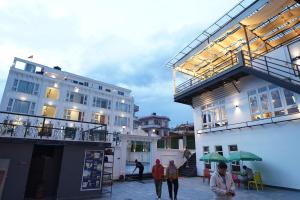 a group of people walking in front of a building at Lotus Shines & Amenities in Manamaiju