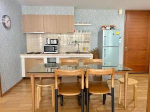 a kitchen with a table with chairs and a refrigerator at บ้านแสนสุขคอนโดติดทะเล By Nichahome in Hua Hin