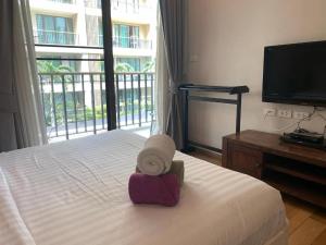 a hotel room with a bed with a hat on it at บ้านแสนสุขคอนโดติดทะเล By Nichahome in Hua Hin +15 photos