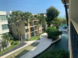 an apartment building with palm trees and a river at บ้านแสนสุขคอนโดติดทะเล By Nichahome in Hua Hin