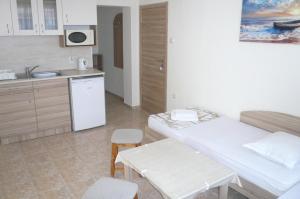 a room with a kitchen and a table and a sink at Къща за гости Мишел in Nesebar
