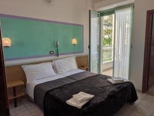 a bedroom with a large bed and a balcony at Hotel Dover Rooms & Coffee Adults Friendly in Cervia