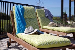 a pair of chairs with hats sitting on them at Lodore Lodge in Kerikeri