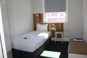 a small room with a bed and a window at Criterion Hotel Gundagai in Gundagai