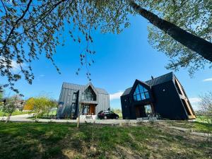 a black house with a gray roof and windows at EcoTravel New in Suceava
