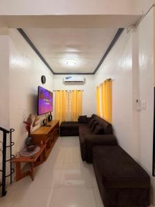 a living room with a couch and a tv at Rose Haven Staycation Panabo in Panabo