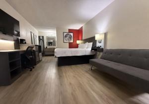 a hotel room with a bed and a couch at Ramada by Wyndham Harrisonburg in Harrisonburg +32 photos