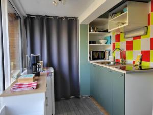 a kitchen with a black curtain and a sink at T1 rez de jardin proche mer in Plérin