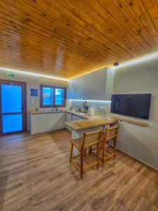a large kitchen with a table and two chairs at Vista Mare 2 in Kámpos
