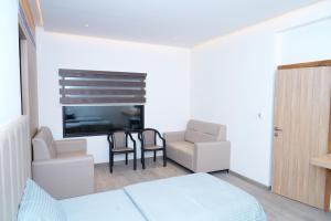 a bedroom with a bed and a table and chairs at Hotel Avani Grand in Zahirābād