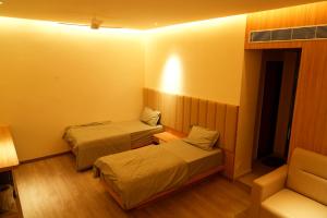a small room with two beds and a couch at Hotel Avani Grand in Zahirābād +12 photos