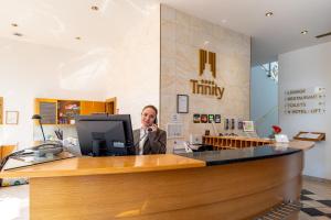 a man talking on a cell phone behind a counter at Hotel Trinity in Olomouc +39 photos