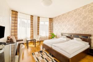a bedroom with a bed and a living room at Hotel Trinity in Olomouc