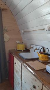 a kitchen counter with a sink in a tiny house at Su Niberalzu glamping in Fermata di Enas +3 photos