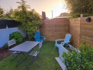 a table and chairs in a backyard with a fence at T1 rez de jardin proche mer in Plérin