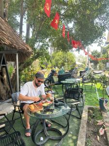 a man sitting at a table with a plate of food at Homestay Mẹ Mít in Cu Chi