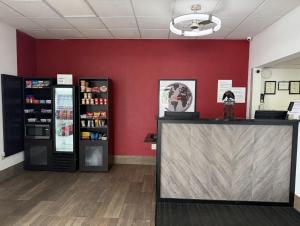 a store with red walls and a counter and two refrigerators at Ramada by Wyndham Harrisonburg in Harrisonburg