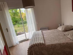 a bedroom with a bed and a large window at Chez Christine in Callian