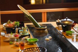 a table with a tray with food on it at 夫婦露天風呂の宿吟松 in Ibusuki