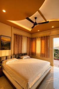 a bedroom with a large bed with a ceiling fan at M2LambardaarStay in Kandogal