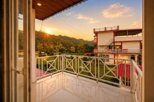 a balcony with a view of the sunset at M2LambardaarStay in Kandogal