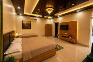 a bedroom with a bed and a flat screen tv at M2LambardaarStay in Kandogal