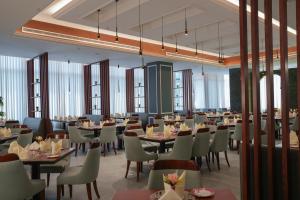 a dining room with tables and chairs and windows at Warwick Hotel Al Safa - Jeddah in Jeddah