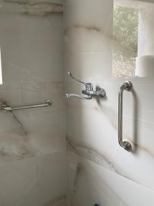 a shower in a bathroom with a shower facet at Kaloniki Rooms & Suites in Masouri +104 photos