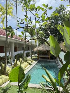 a swimming pool in front of a villa at Nira Hostel Kuta Lombok in Kuta Lombok
