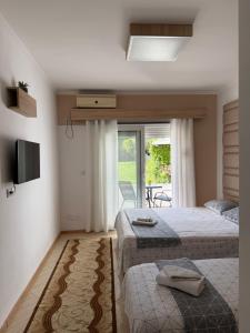 a hotel room with two beds and a television at Ajan Apartments in Ulcinj